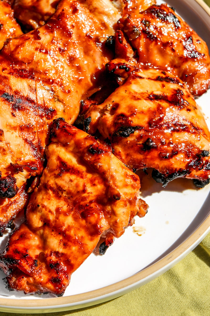 an up close look at three pieces of huli huli chicken with grill marks. 