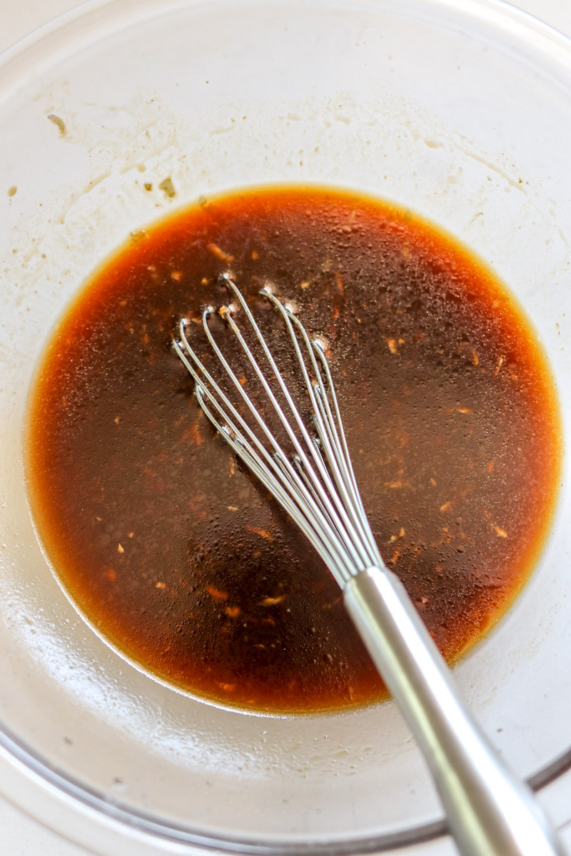 a bowl of huli huli sauce with a whisk in it. 