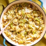 sauteed cabbage and onions in a blue skillet.