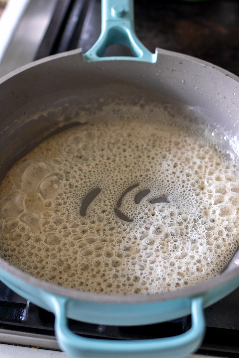 roux bubbling and cooking in a blue pan. 