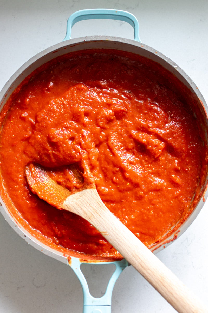 a blue pot filled with red southern tomato gravy, 