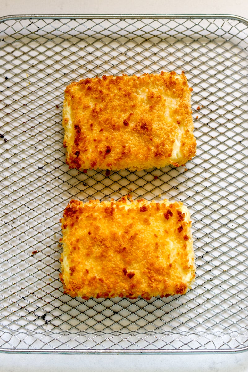 crispy fried feta pieces in a fryer basket.