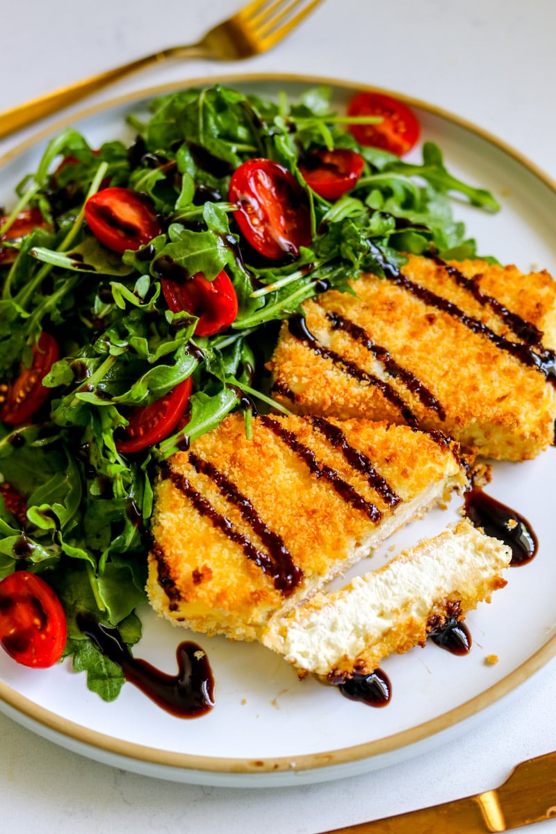 two pieces of fried feta with balsamic drizzle on top.