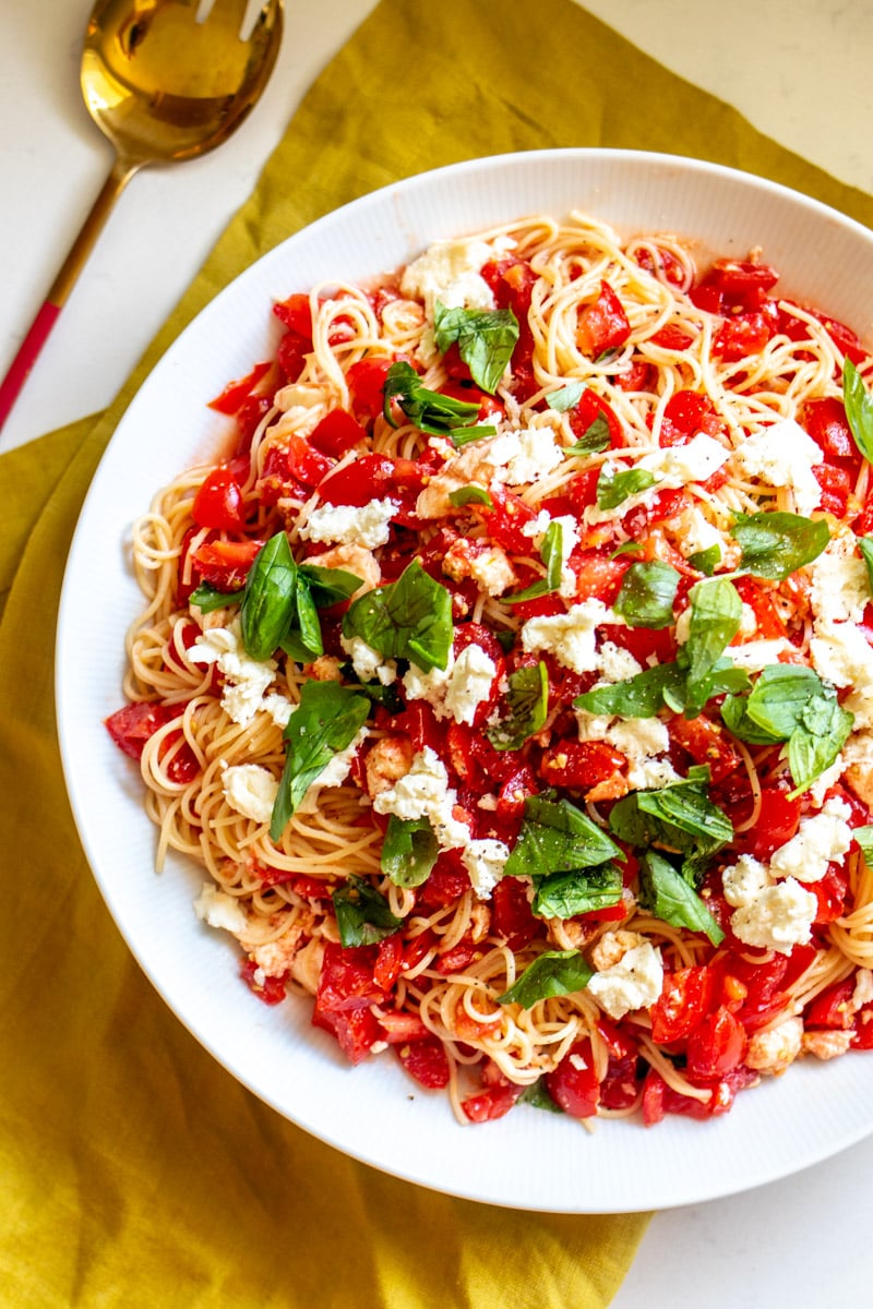 the left side of a bowl of bruschetta pasta salad.