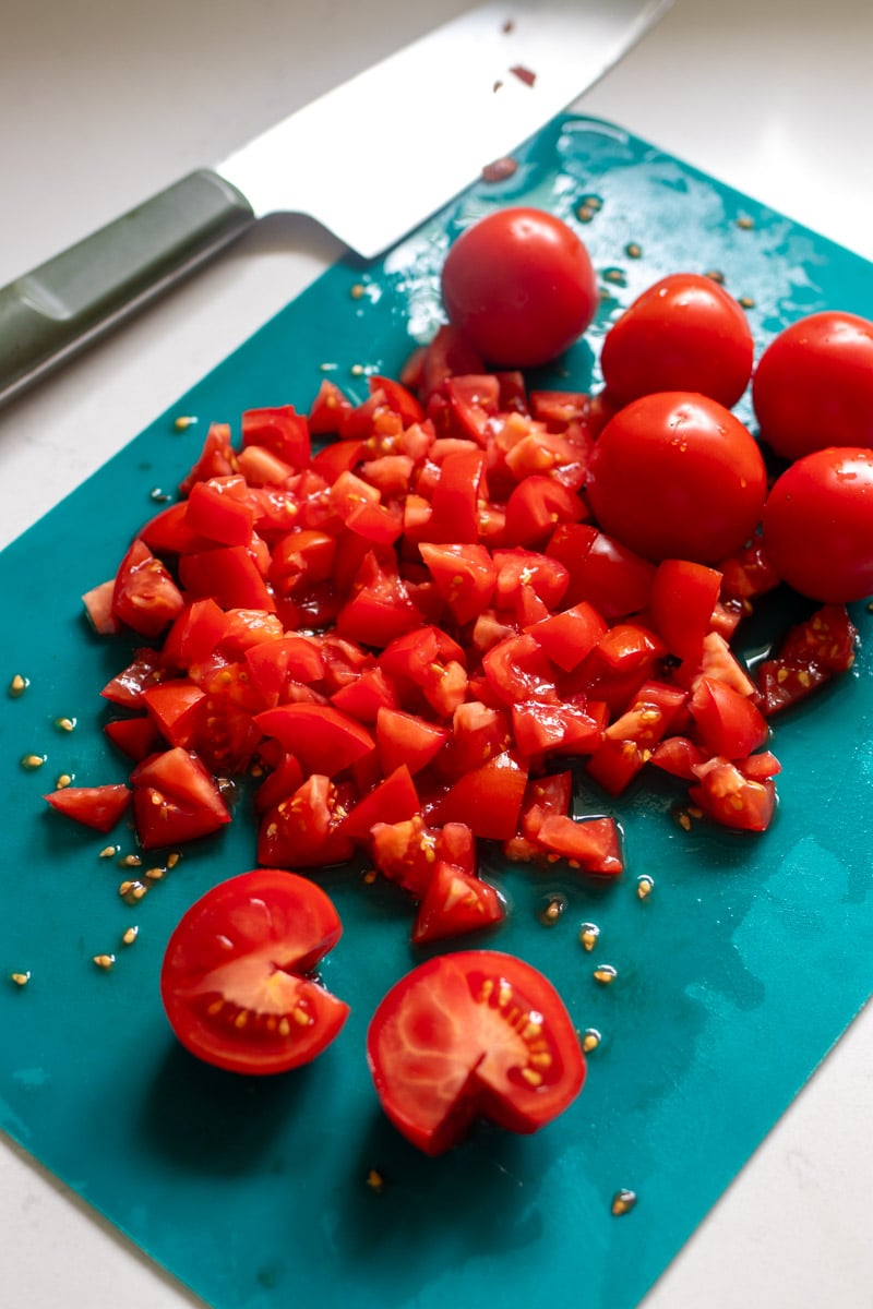 chopped tomatoes on a blue cutting board.