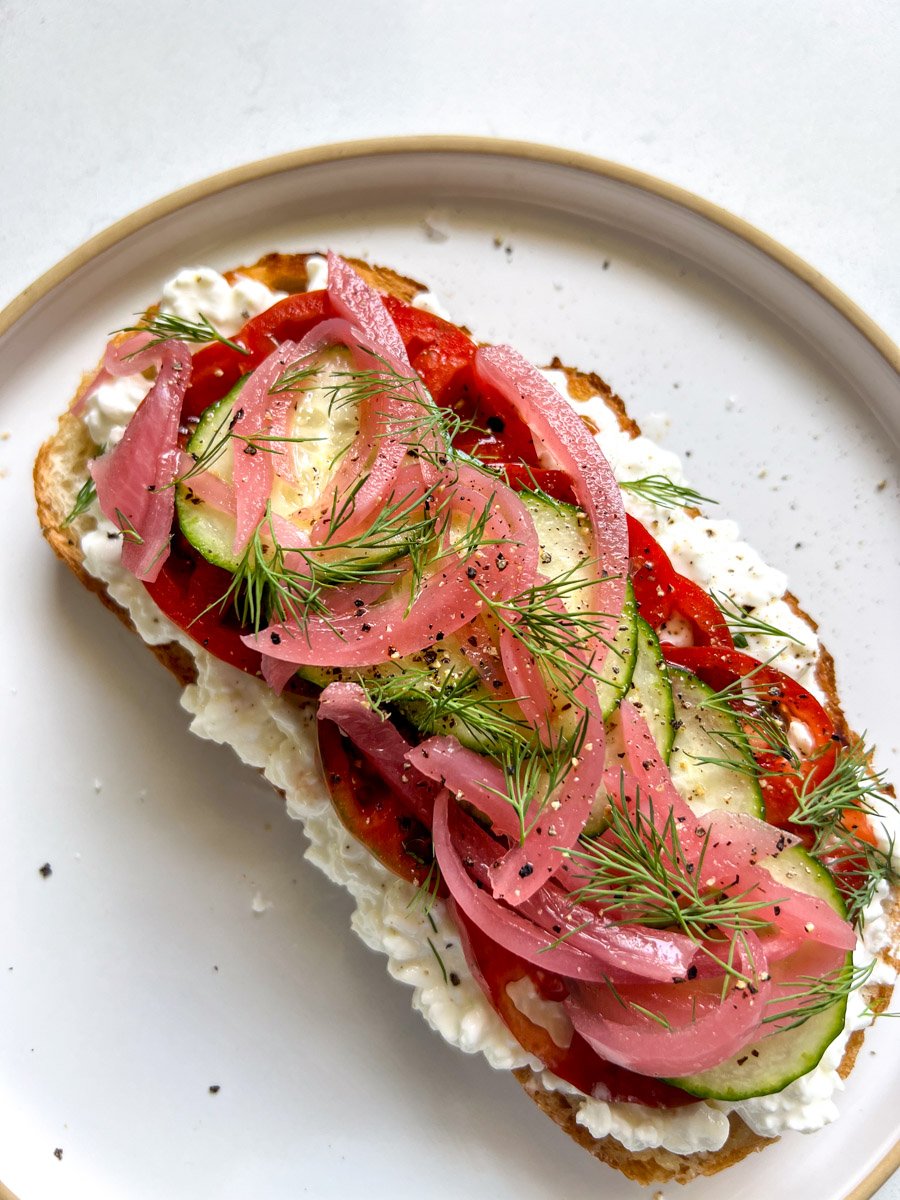 loaded veggies on top of a slice of cottage cheese toast.