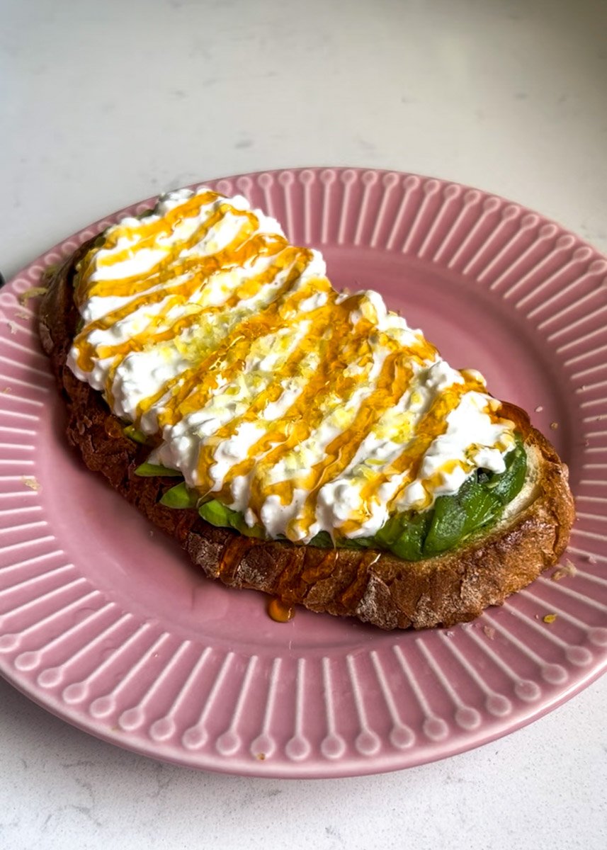 avocado cottage cheese toast on a pink plate.