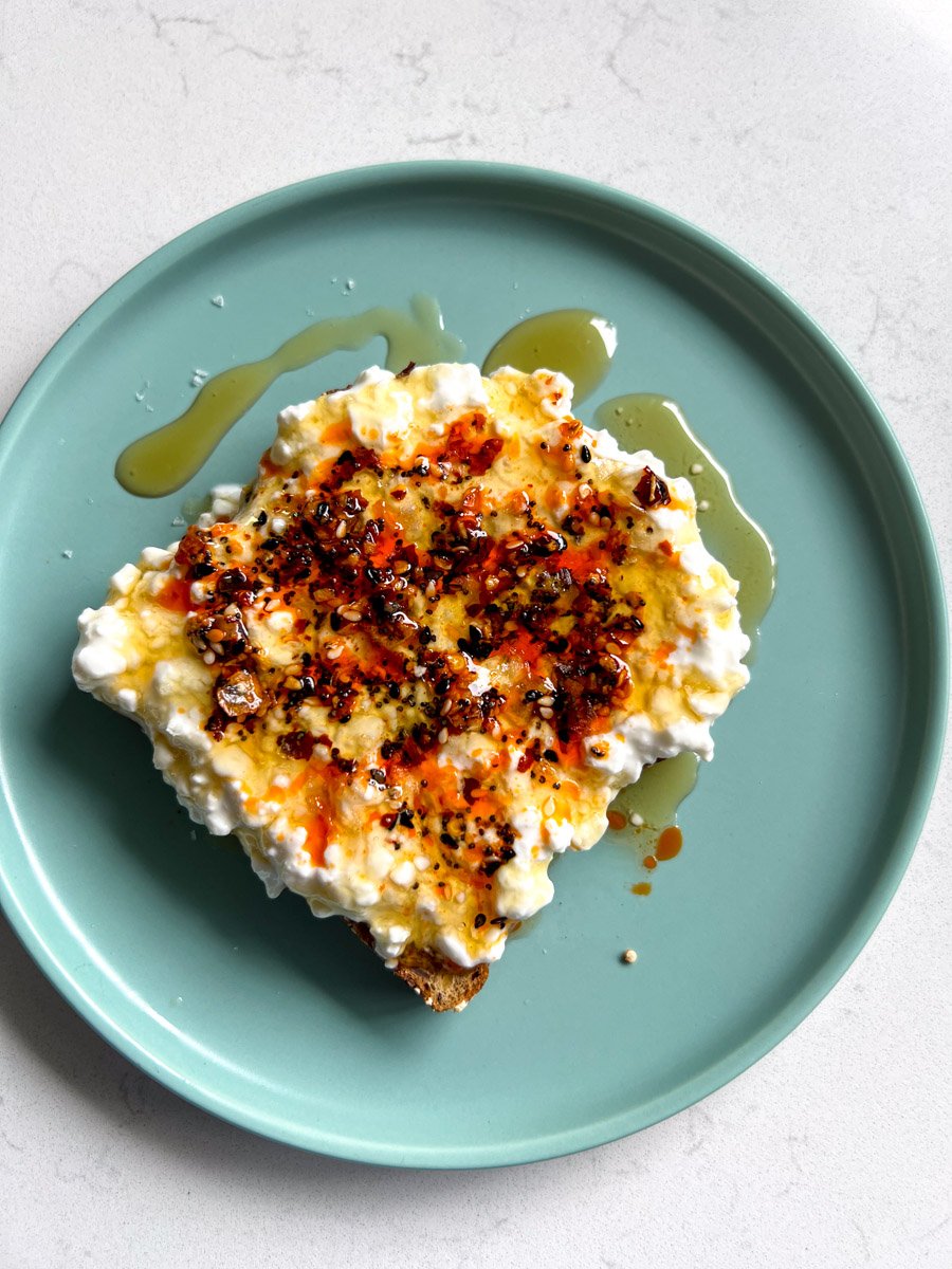 a slice of protien bread topped with cottage cheese, honey and crispy chili oil.