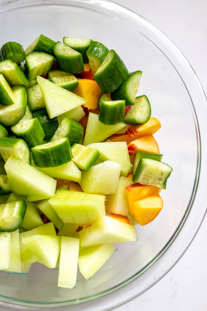 chopped fruit and vegetables in a clear glass bowl.