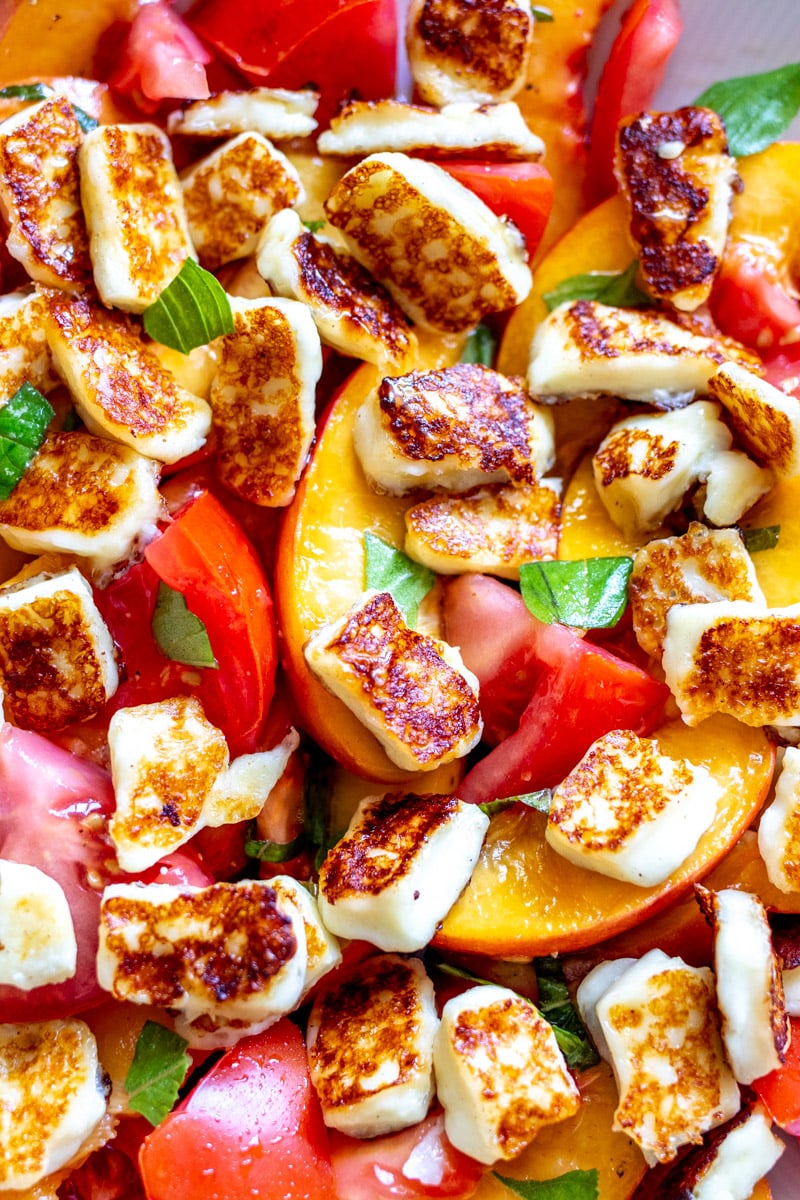 an up close view of a peach halloumi salad.