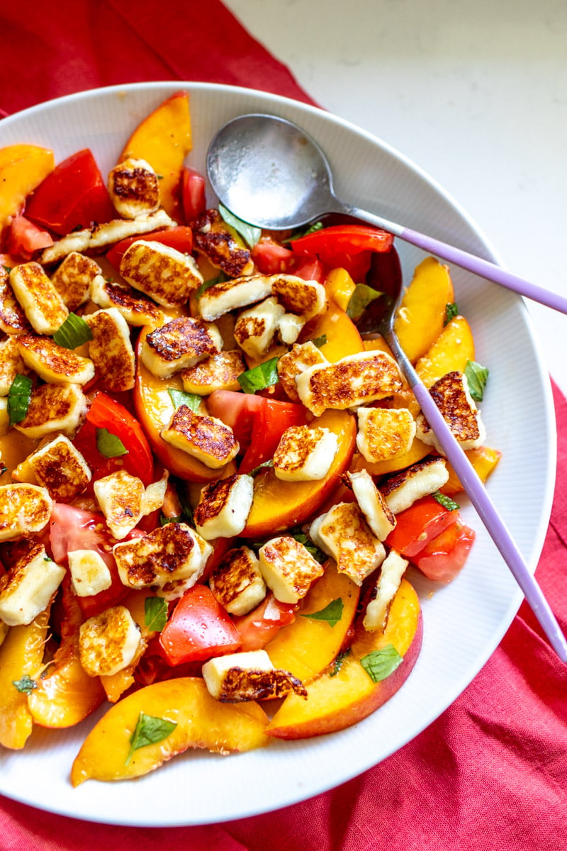 fresh chopped peaches and tomatoes in a large bowl with basil and hot honey.