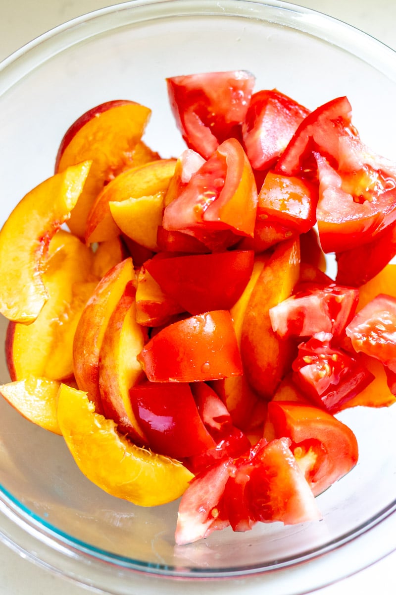 chopped peaches and tomatoes in a measuring bowl.