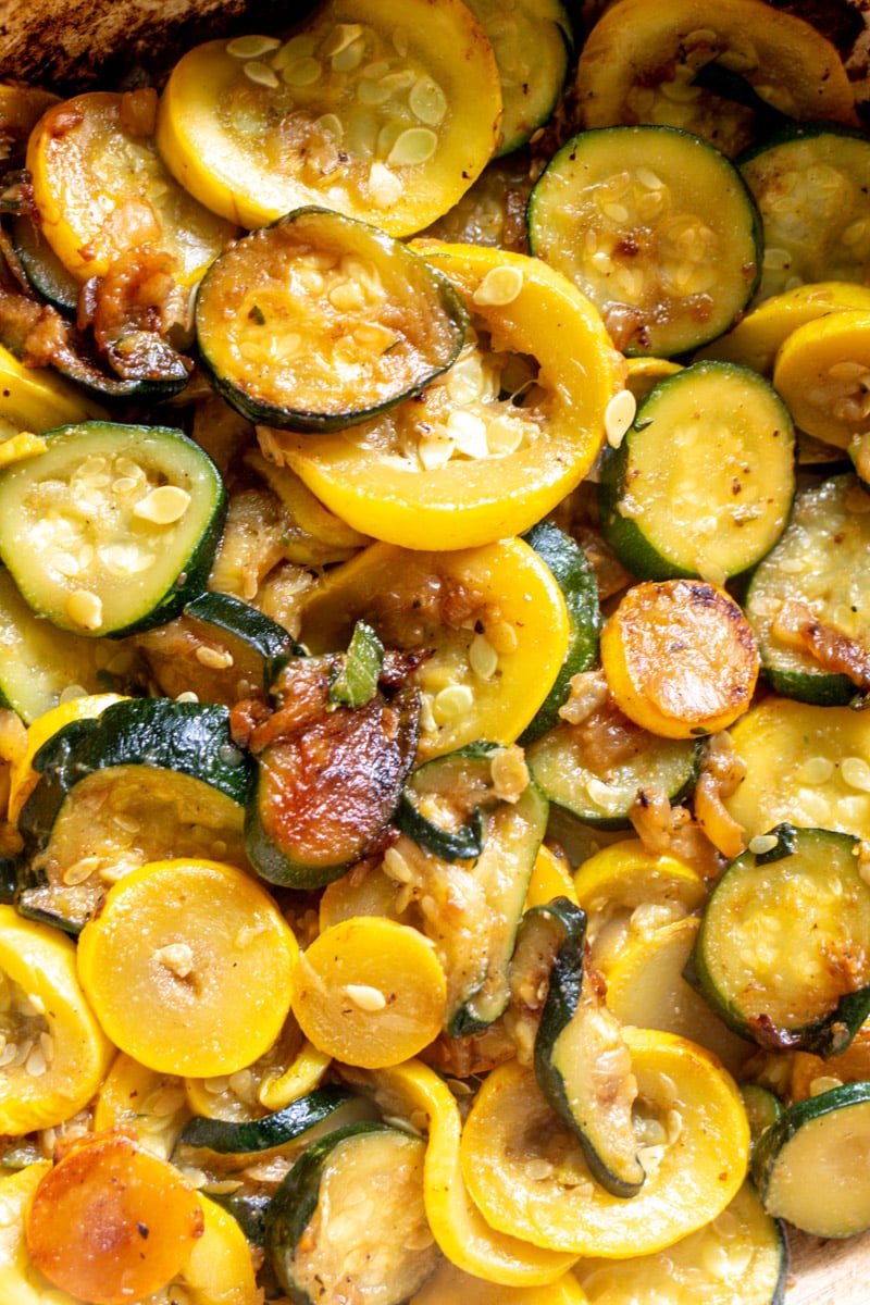 a closeup of zucchini and squash on the stovetop. 