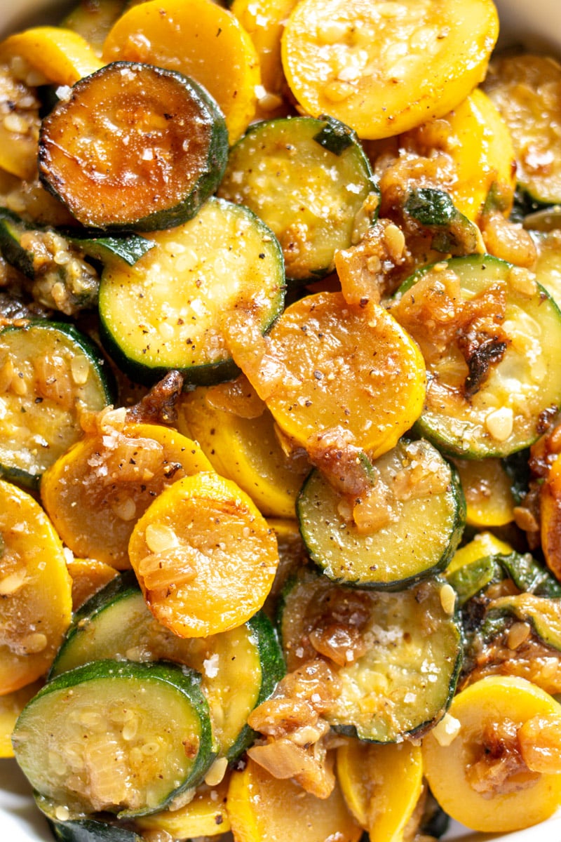 a close up image of sauteed yellow squash and zucchini.