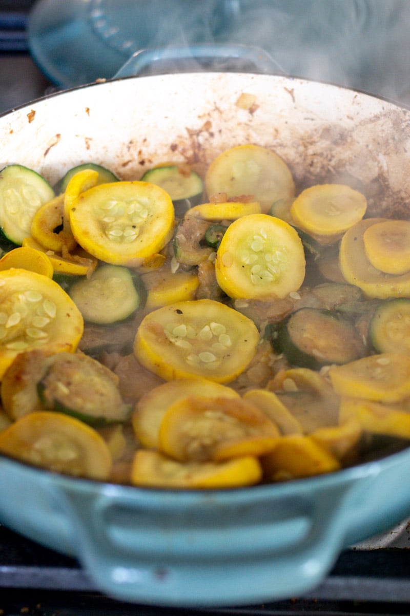 squash and zucchini cooking on the stovetop. 