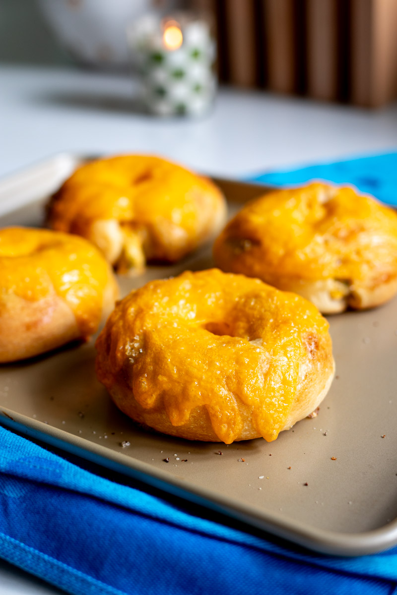 a baking sheet full of baked broccoli cheese crescent roll bagels.