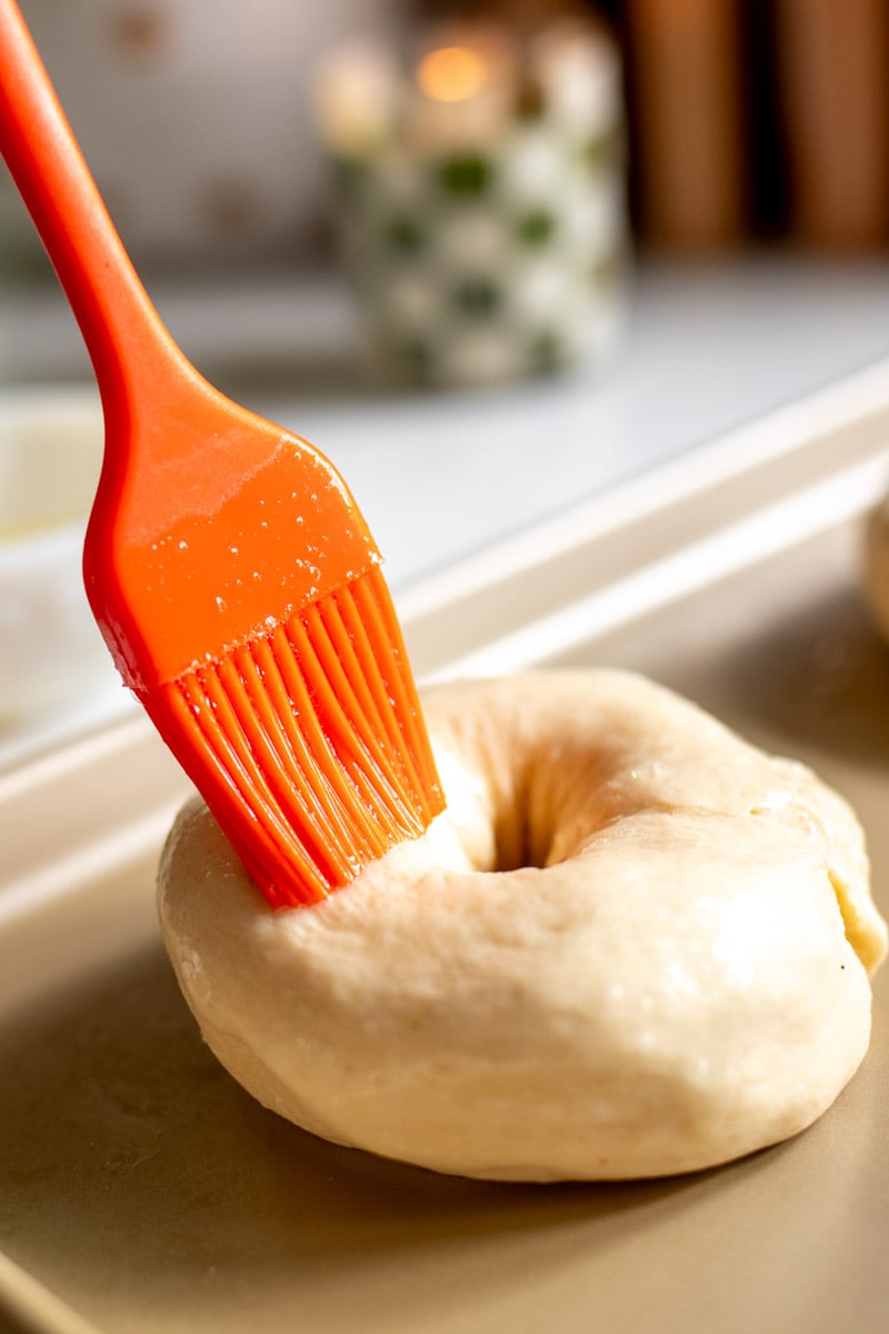 broccoli cheese crescent roll bagels being brushed with egg white. 