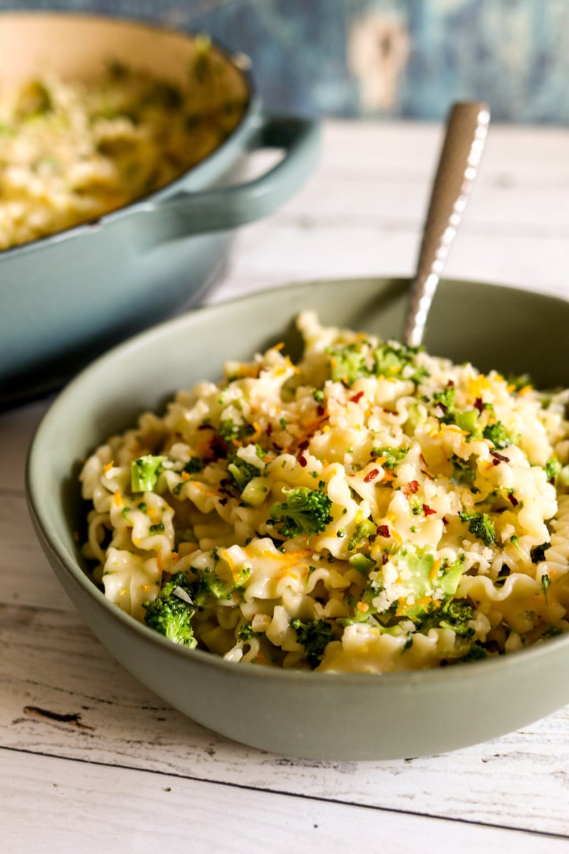 a small green bowl of broccoli pasta. 