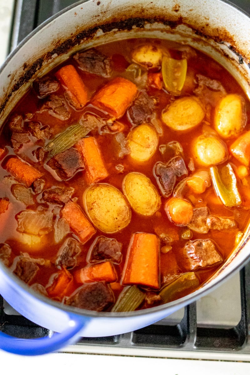 a dutch oven filled with beef stew before it's thickened.