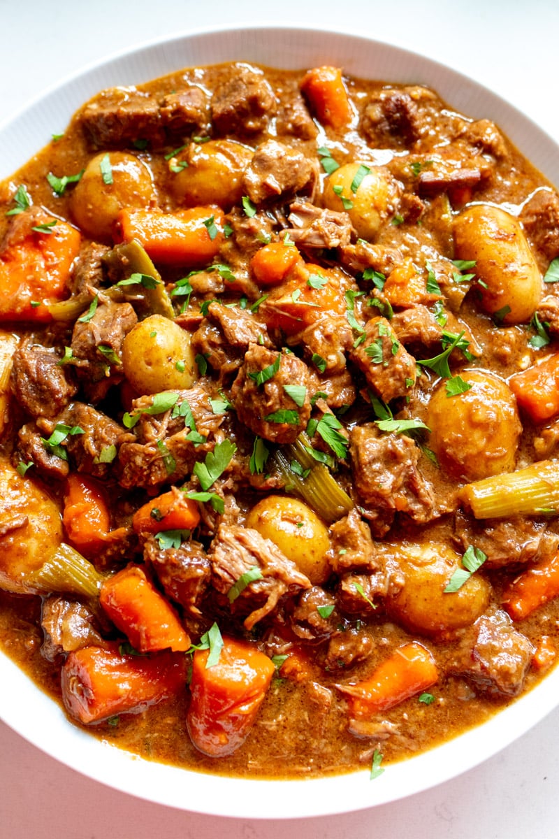 a big bowl of beef stew made in a dutch oven.