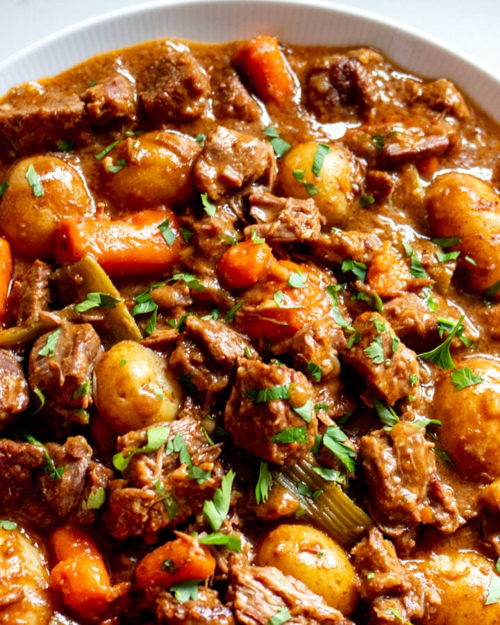 a white bowl filled with dutch oven beef stew.