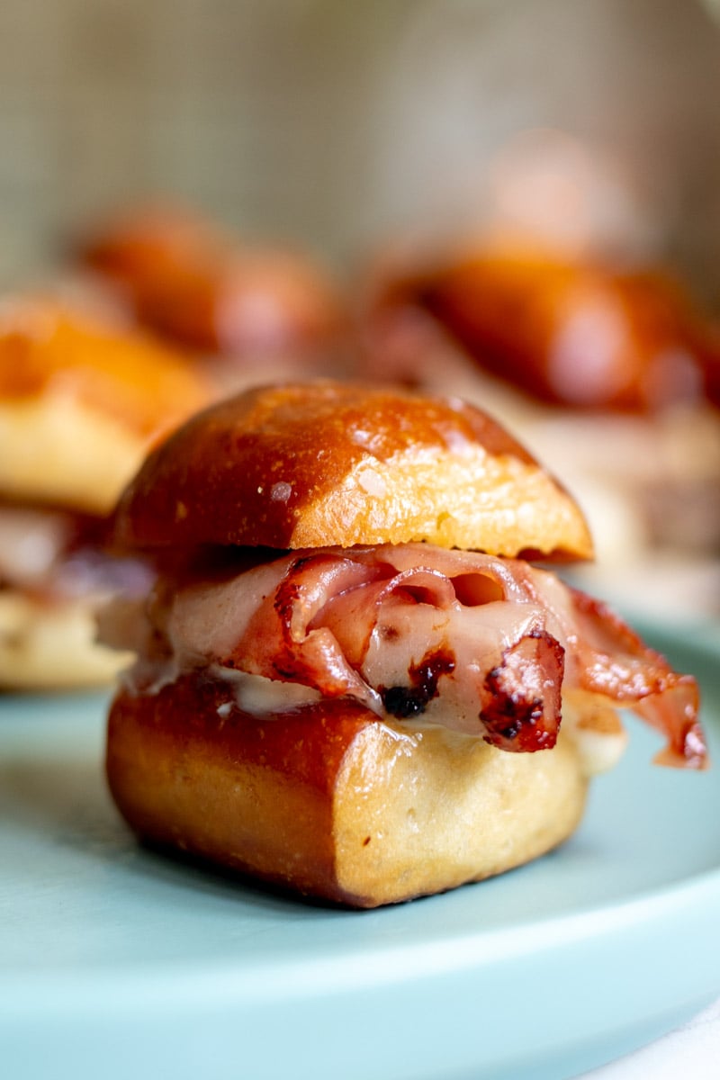 a single fried mortadella sandwich on a blue plate with a few in the background.