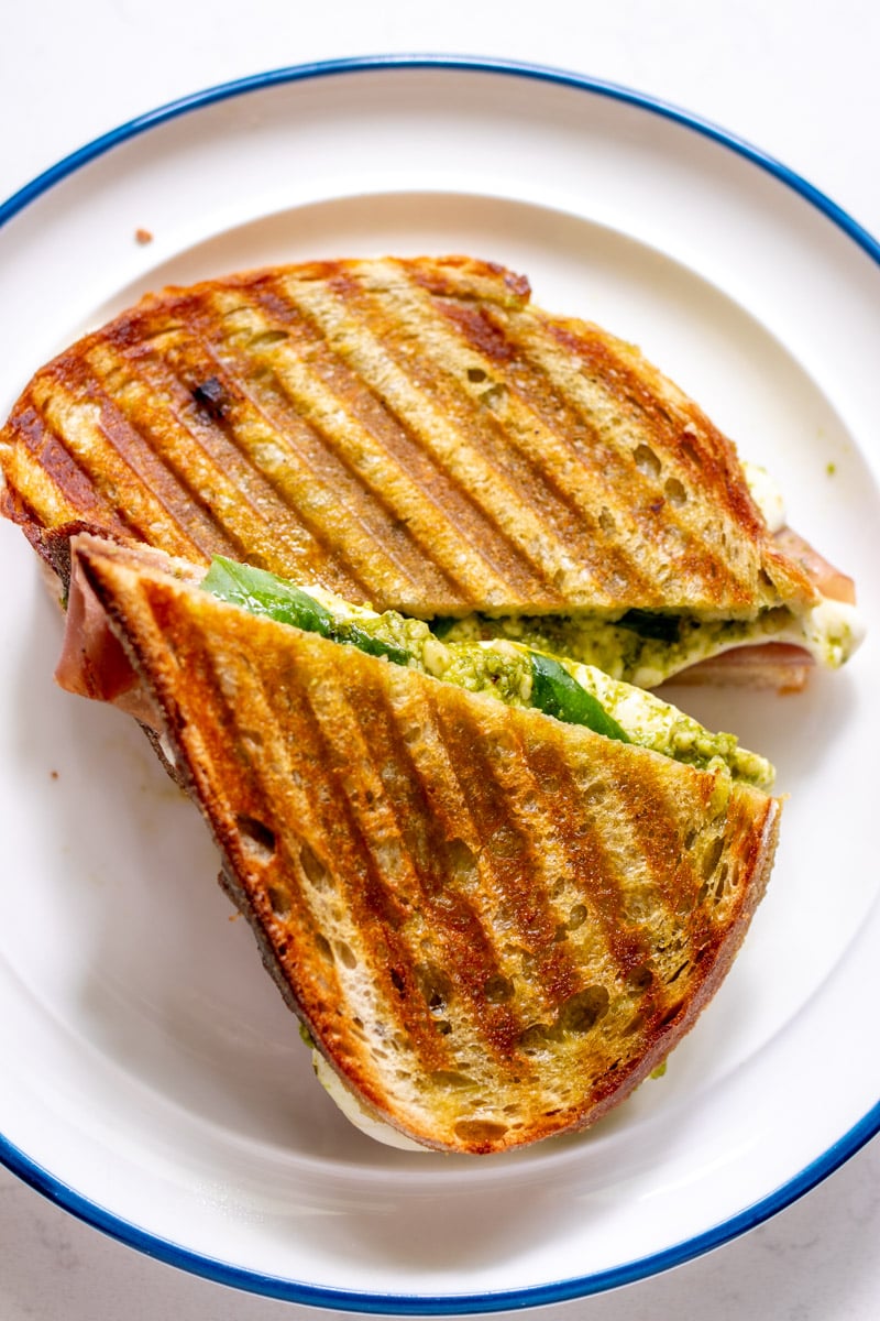 a panini cut in half on a white plate.