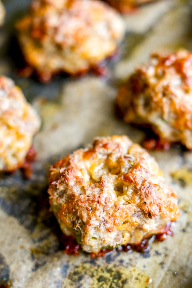 an up close view of a sausage ball on a baking sheet.