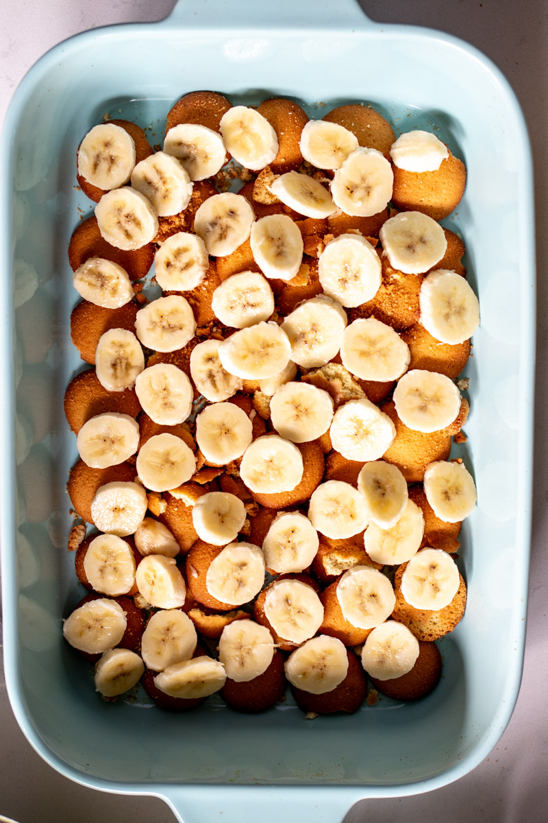 sliced banana on top of nilla wafers in a blue serving bowl.