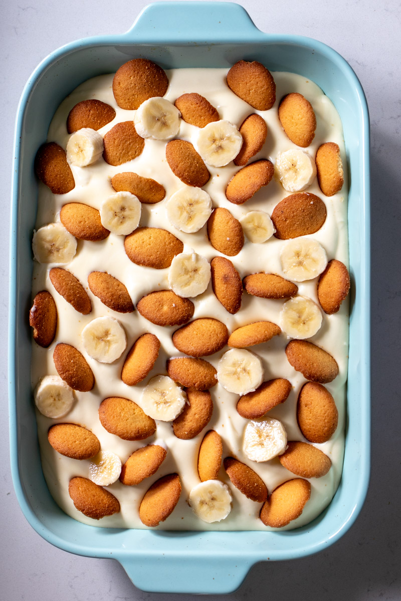 my mom's classic southern banana pudding with condensed milk in a blue casserole dish.