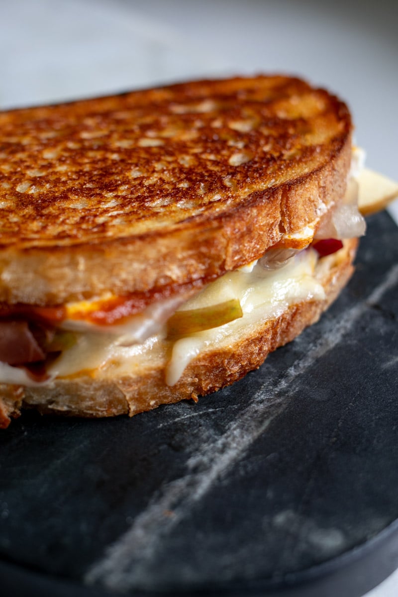 a grilled cheese resting on a cutting board.