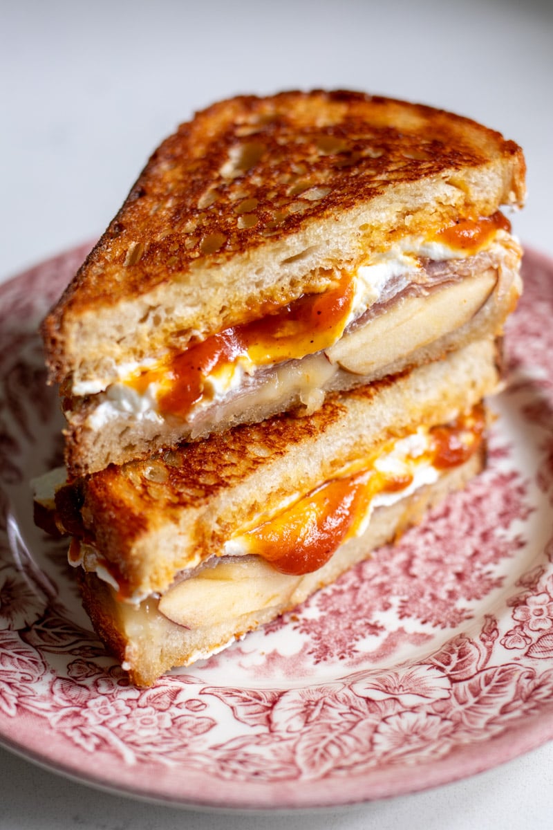 Trader Joe's Pumpkin Butter grilled cheese cut in half sitting on a red and white plate.