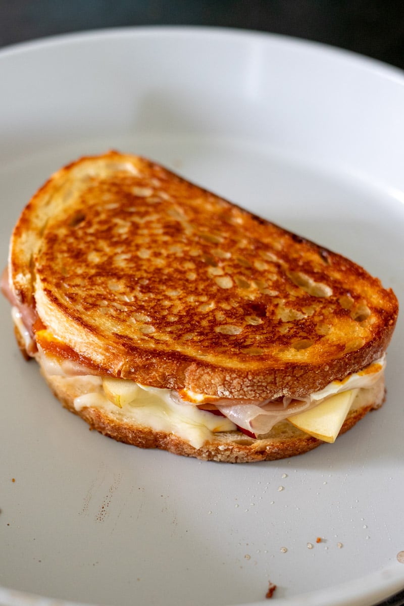 a fall themed grilled cheese in a frying pan.