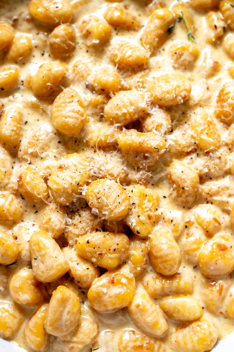 an up close view of the texture of the pumpkin gnocchi in cream sauce. 