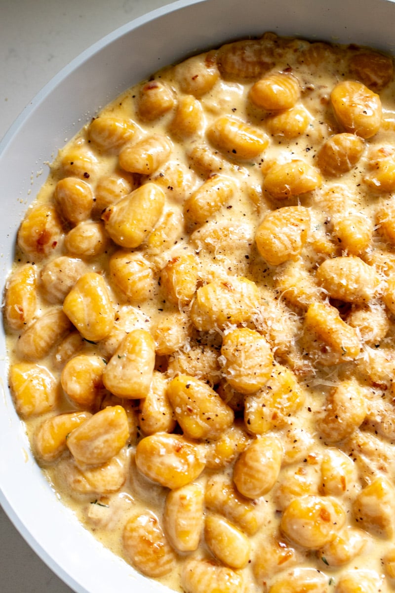 the lefty side of a skillet full of creamy gnocchi.