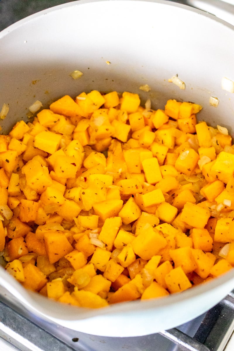 cubes of butternut squash browning in a big soup pot.