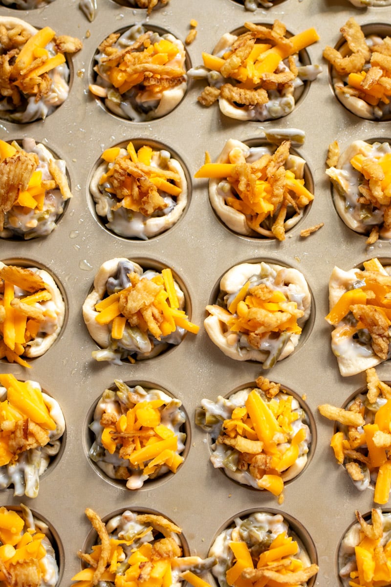 uncooked green bean casserole with crescent roll dough in a mini muffin tin. 