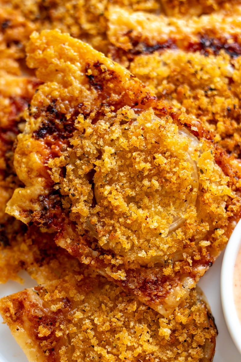 an up close view of a singlular gruyere crusted onion bite. 