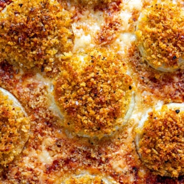 an overhead view of gruyere crusted onions on a baking sheet.