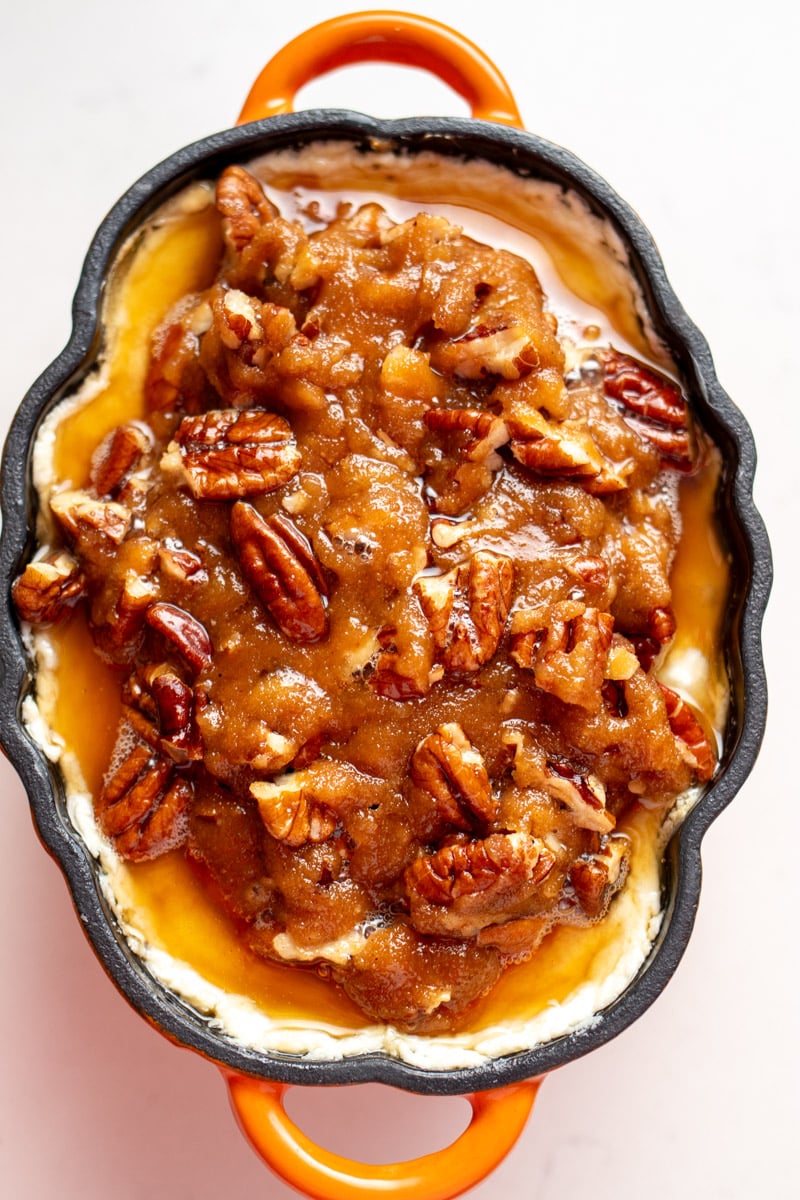 an overhead view of a pumpkin ramekin filled with caramelized pecan pie and whipped goat cheese dip.