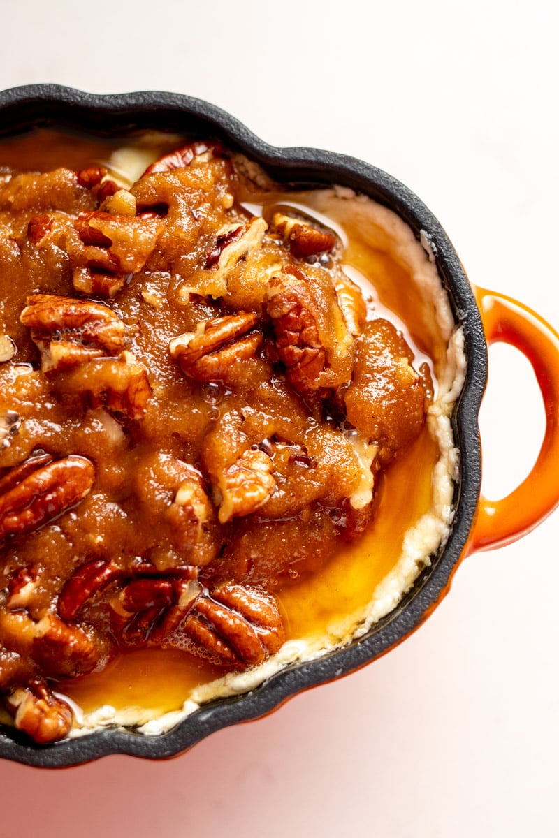 an overhead of pecan pie topping over goat cheese.