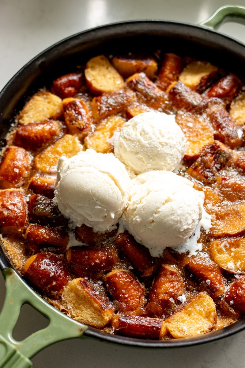 an overhead view of pretzel bread pudding with three scoops of white ice cream.