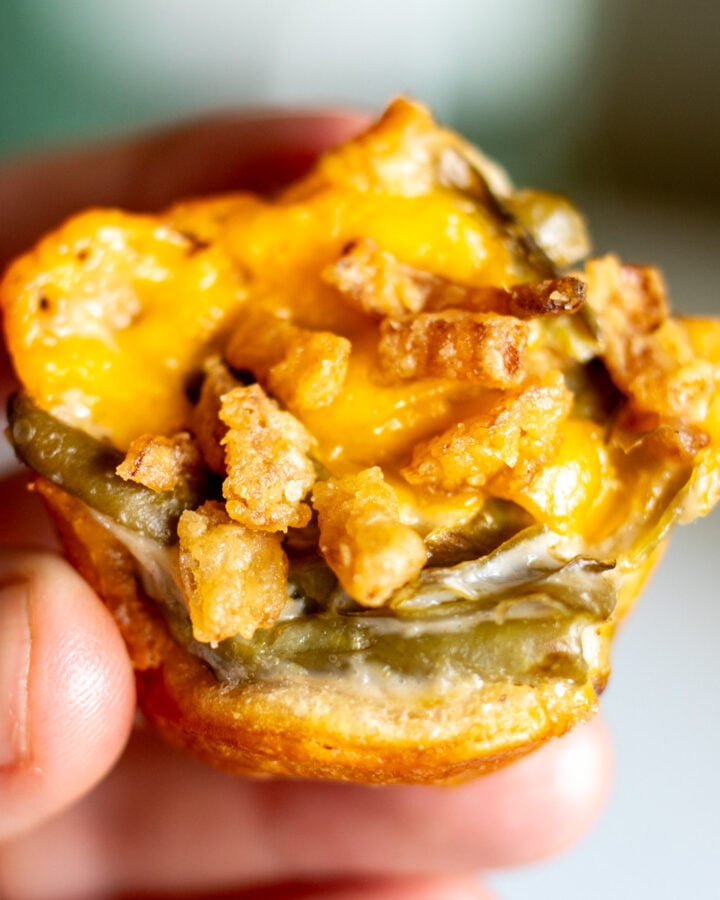 a hand holding a singular green bean casserole appetizer bite.