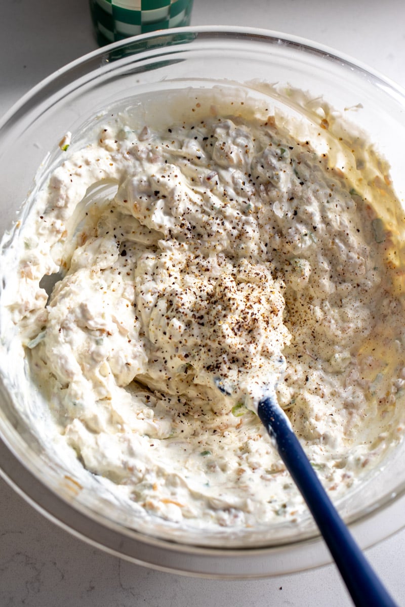 caramelized onion dip with fresh cracked pepper on top in a white bowl.