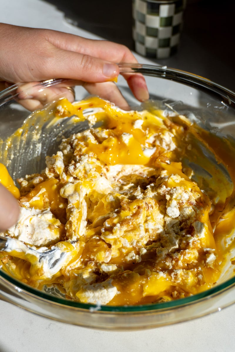 a glass bowl filled with the creamy cheesy sauce for broccoli casserole.