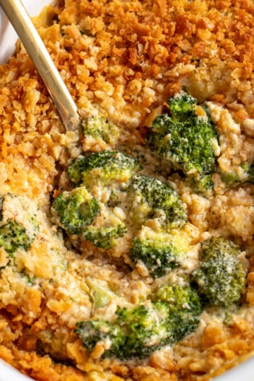 a casserole dish filled with a creamy cheesy broccoli casserole recipe.