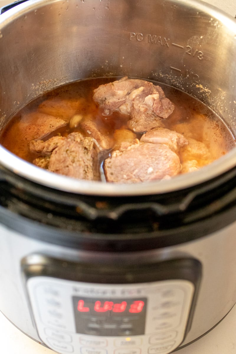 chunks of pork butt and braising liquid in a instant pot pressure cooker.