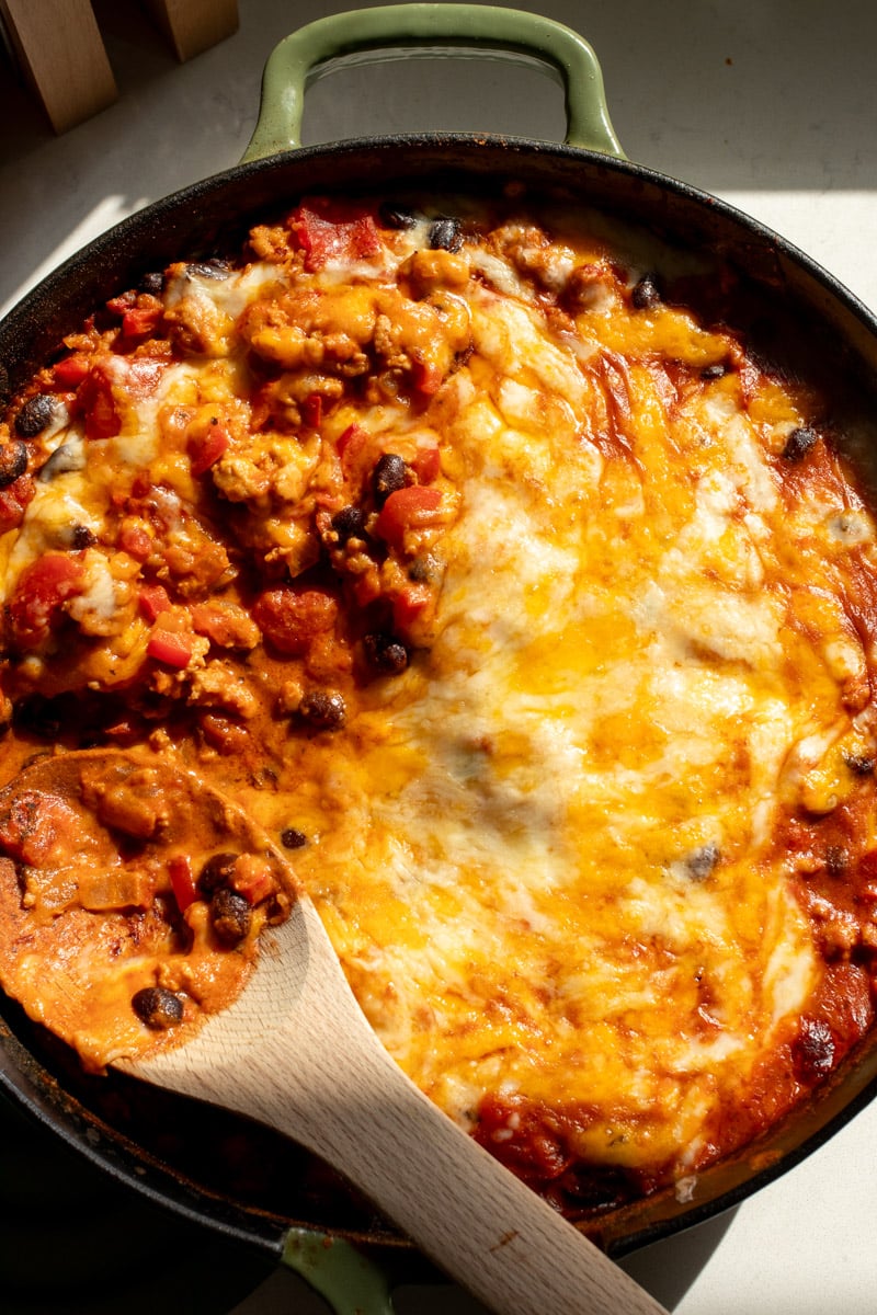 a cast iron skillet full of cheesy chipotle chicken. 