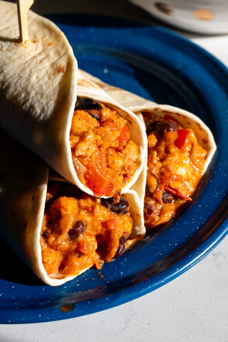 a couple of ground chicken tacos with melted cheese sitting on a plate.