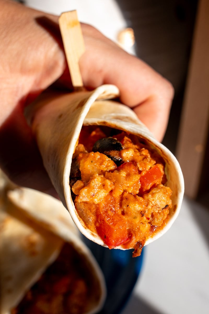 a hand holding a taco filled with this cheesy chipotle chicken skillet.